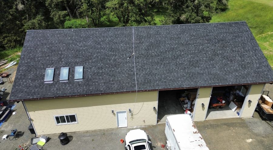 Dark asphalt shingle roof on a shop building